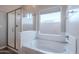 Bright bathroom showcases a separate shower stall and bathtub with a frosted window for natural light at 809 W Coles Rd, Phoenix, AZ 85041