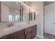 Modern bathroom featuring dual sinks, wood cabinets, and stylish lighting fixtures above the framed mirrors at 809 W Coles Rd, Phoenix, AZ 85041