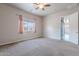 Cozy bedroom with neutral carpeting, a ceiling fan, and a sunlit window at 809 W Coles Rd, Phoenix, AZ 85041