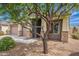 This home has a spacious front yard and an inviting entrance enhanced by stone accents and a mature tree at 809 W Coles Rd, Phoenix, AZ 85041