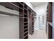 Organized walk-in closet with dark wood shelving, rods, and a mirrored door for full-length viewing at 809 W Coles Rd, Phoenix, AZ 85041