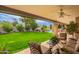 Inviting covered back patio with a ceiling fan, lush lawn, outdoor seating, and a glimpse of the sparkling pool at 8851 S Juniper St, Tempe, AZ 85284