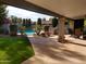 Covered patio overlooks the pool, lush landscaping, and outdoor kitchen area in the backyard at 8851 S Juniper St, Tempe, AZ 85284