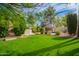 Backyard featuring a manicured lawn, mature trees, and a covered cabana that creates a tranquil outdoor living space at 8851 S Juniper St, Tempe, AZ 85284