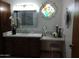 Bathroom with a vanity, decorative stained glass window and unique wrought iron wall art at 8851 S Juniper St, Tempe, AZ 85284