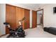 Bedroom area with an exercise bike and a closet with wood sliding doors at 8851 S Juniper St, Tempe, AZ 85284