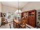 Elegant dining room with chandelier, large hutch, and bright light from large window at 8851 S Juniper St, Tempe, AZ 85284