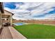 Backyard showcasing a sparkling pool, well-maintained grass, and a covered patio with seating at 9508 W Jj Ranch Rd, Peoria, AZ 85383