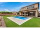 Beautiful backyard with pool, patio, green grass, and manicured landscaping for a serene outdoor experience at 9508 W Jj Ranch Rd, Peoria, AZ 85383