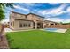 Expansive backyard featuring a sparkling pool, covered patio, and lush green grass at 9508 W Jj Ranch Rd, Peoria, AZ 85383