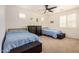 Bright bedroom featuring two twin beds, ceiling fan, and ample natural light at 9508 W Jj Ranch Rd, Peoria, AZ 85383