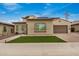 Inviting single-story home with tan stucco, tidy artificial turf, and a paved driveway leading to a two-car garage at 9508 W Jj Ranch Rd, Peoria, AZ 85383