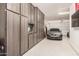 Spacious three-car garage with epoxy flooring and custom wood-tone cabinetry at 9508 W Jj Ranch Rd, Peoria, AZ 85383