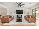 Elegant living room with hardwood floors, plush sofas, and a large TV, perfect for relaxation and entertainment at 9508 W Jj Ranch Rd, Peoria, AZ 85383