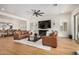 Open-concept living room features hardwood floors, leather couches, a ceiling fan, and sliding glass doors at 9508 W Jj Ranch Rd, Peoria, AZ 85383