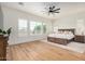 Bright main bedroom featuring plantation shutters, ceiling fan, and wood-look flooring at 9508 W Jj Ranch Rd, Peoria, AZ 85383