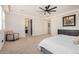 Spacious main bedroom featuring neutral decor, plush carpeting, ceiling fan, and ensuite bath at 9508 W Jj Ranch Rd, Peoria, AZ 85383