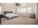 Spacious main bedroom featuring a ceiling fan, multiple windows, and plush carpeting at 9508 W Jj Ranch Rd, Peoria, AZ 85383