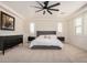 Large primary bedroom with neutral colors, plush carpet, and a decorative ceiling fan at 9508 W Jj Ranch Rd, Peoria, AZ 85383