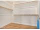 Well-lit walk-in closet with wood floors, ample shelving, and hanging storage at 9508 W Jj Ranch Rd, Peoria, AZ 85383