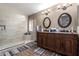 Bathroom featuring a double sink vanity, walk-in shower, and decorative mirrors at 1147 N Marvin St, Gilbert, AZ 85233