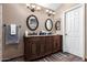 Bathroom featuring a double sink vanity, decorative mirrors, and neutral colored walls at 1147 N Marvin St, Gilbert, AZ 85233