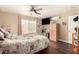 Bedroom with hardwood floors, natural lighting from the window, a TV, and ceiling fan at 1147 N Marvin St, Gilbert, AZ 85233