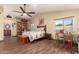 Bedroom featuring beautiful hardwood flooring, a window with natural light, and a ceiling fan at 1147 N Marvin St, Gilbert, AZ 85233
