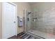 Modern bathroom shower featuring frameless glass, neutral tiling, and a built-in shelf niche at 1147 N Marvin St, Gilbert, AZ 85233