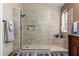 Modern bathroom shower featuring frameless glass, neutral tiling, and a built-in shelf niche at 1147 N Marvin St, Gilbert, AZ 85233