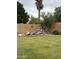 Spacious backyard with green grass and charming rock waterfall feature with colorful decor on the walls at 135 S Abalone Dr, Gilbert, AZ 85233