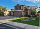 Two-story home with tan exterior, brown trim, landscaped yard, and two car garage at 135 S Abalone Dr, Gilbert, AZ 85233
