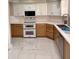Modern kitchen with white and natural wood cabinets, stainless steel appliances, and white marble floors at 135 S Abalone Dr, Gilbert, AZ 85233