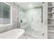 Modern bathroom features marble walls, glass shower with seat, and a soaking tub, offering a spa-like experience at 1532 W Northern Ave, Phoenix, AZ 85021