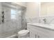 Well-lit bathroom features marble tile, a glass-enclosed shower, and a sleek vanity with modern fixtures at 1532 W Northern Ave, Phoenix, AZ 85021