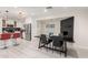 Elegant dining room area with a black table and seating near a fireplace and modern kitchen at 1532 W Northern Ave, Phoenix, AZ 85021