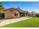 Back of house overlooking the backyard with patio, turf grass, and desert landscaping at 15422 W Ventura St, Surprise, AZ 85379