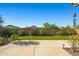 Paver patio and artificial grass backyard featuring colorful shrubs and block wall at 15422 W Ventura St, Surprise, AZ 85379