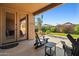 Covered patio with table and chairs overlooks the backyard with artificial grass and block wall at 15422 W Ventura St, Surprise, AZ 85379
