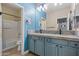 Stylish bathroom featuring a double vanity with marble countertop and blue cabinetry at 15422 W Ventura St, Surprise, AZ 85379
