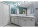 Bathroom featuring a double vanity with granite counters, large mirror, and access to other rooms at 15422 W Ventura St, Surprise, AZ 85379