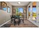Bright dining area with wood-look tile floors, an outdoor view, a glass table, and chairs, open to the exterior at 15422 W Ventura St, Surprise, AZ 85379