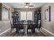 Formal dining room with dark wood furniture, a ceiling fan, and neutral paint, filled with decorative elements at 15422 W Ventura St, Surprise, AZ 85379