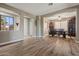 Open-concept dining room with wood tile flooring, ample natural light, and a view of an adjacent living area at 15422 W Ventura St, Surprise, AZ 85379