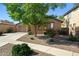 Charming home with a well-manicured front yard featuring desert landscaping and a mature shade tree at 15422 W Ventura St, Surprise, AZ 85379