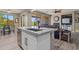Kitchen island with stainless sink, seating, and a view into the living room and the backyard at 15422 W Ventura St, Surprise, AZ 85379