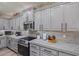 Kitchen with bright gray cabinetry, stainless steel appliances, and light countertops, exuding a clean, modern aesthetic at 15422 W Ventura St, Surprise, AZ 85379