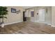 View of living room featuring wood-look tile flooring, neutral walls, and a bright entryway with an oversized front door at 15422 W Ventura St, Surprise, AZ 85379