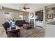Cozy living room with fireplace, large windows, and comfortable leather seating with a ceiling fan at 15422 W Ventura St, Surprise, AZ 85379