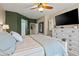 Comfortable main bedroom with a ceiling fan and large dresser with a wall mounted TV at 15422 W Ventura St, Surprise, AZ 85379